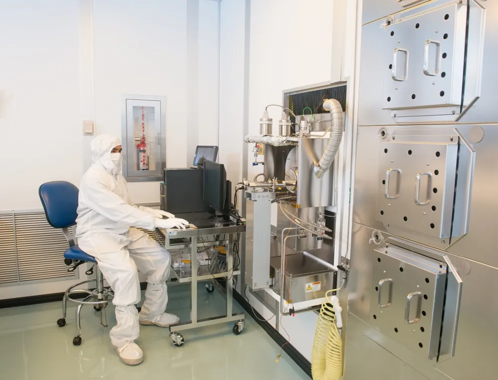 Technicians and semiconductor fabrication equipment inside a NASA cleanroom